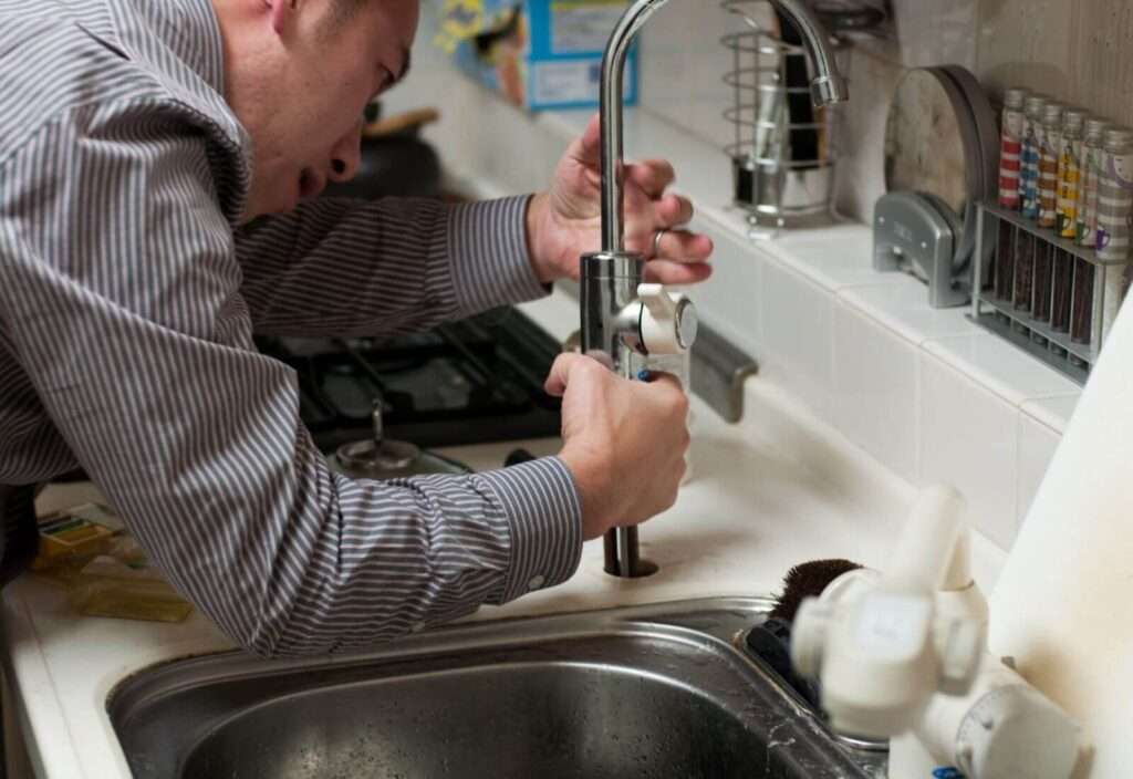 man fixing moen touchless faucet