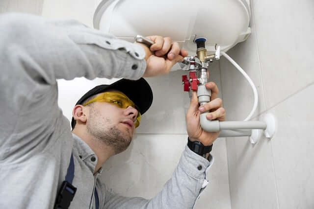 plumber fixing leaking faucet