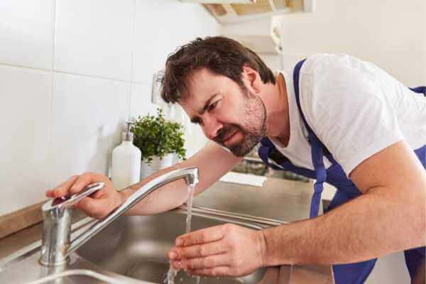 plumber fixing dripping faucet