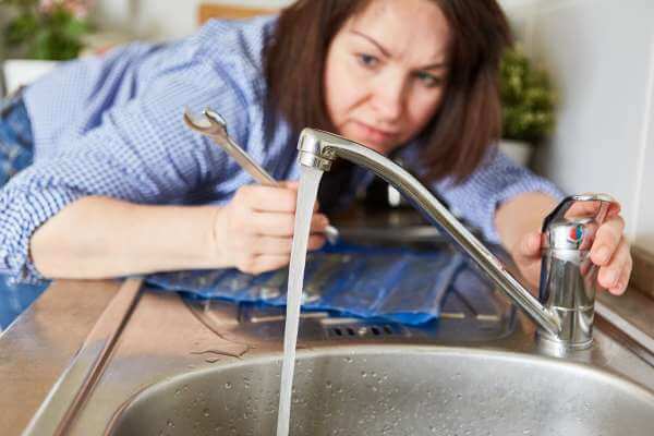 woman Testing the faucet and checking for leaks